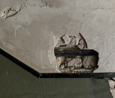 Nahaufnahme einer rauen Betonoberflaeche mit kleiner Markierung