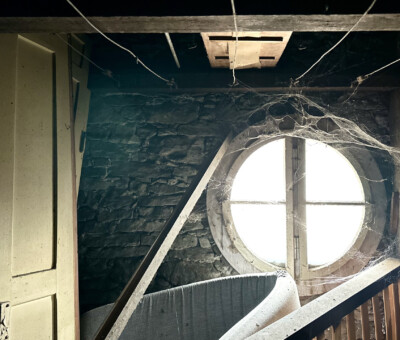 Dunkler Innenraum mit rautenfoermigem Fenster und Deckenleuchte