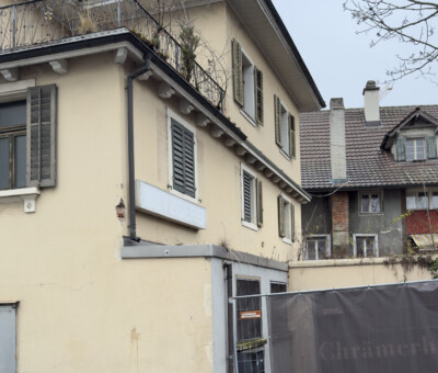 Gebaeude mit Bauzaun im Vordergrund
