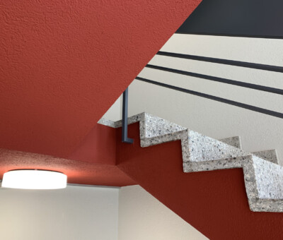 Treppenhaus mit rot-schwarz-weissem geometrischem Wanddesign