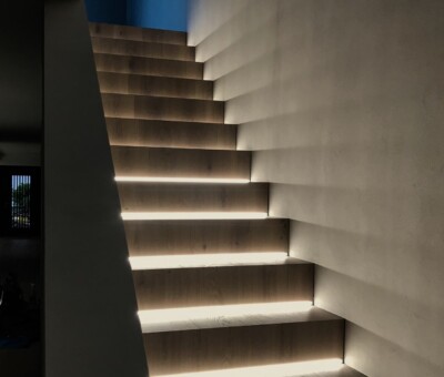 Modernes, geschwungenes Treppenhaus mit in die Stufen integrierter LED-Beleuchtung